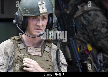 Lance Cpl. Brandon Baker, ein Angriff Amphibienfahrzeug crewman mit Bravo Company, 3 Assault Amphibian Bataillon, Echo, Bataillon Landung Team, 2nd Battalion, 5th Marines, Pausen während einer mechanisierten Angriff als Teil des 31 Marine Expeditionary Unit MEU Übung, in der Nähe der Ginoza Village, Okinawa, Japan, 28. Juni 2018. Baker, ein Eingeborener von Charleston, South Carolina, graduiert von North Charleston High School im August 2016 Vor der Abreise für Rekrutieren Ausbildung im selben Monat. Marinesoldaten und Matrosen mit Echo Unternehmen durchgeführt, um die Endgültige Ausbildung bei MEUEX, ein Angriff la Stockfoto