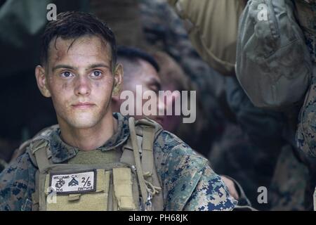 Cpl. Clayton Williams, eine Intelligenz Spezialist mit Echo Company, Bataillon Landung Team, 2nd Battalion, 5th Marines, benötigt eine kurze Pause während einer mechanisierten Angriff als Teil des 31 Marine Expeditionary Unit MEU Übung, in der Nähe der Ginoza Village, Okinawa, Japan, 28. Juni 2018. Williams, ein Eingeborener von Los Angeles, graduierte Agoura Hills High School im Juni 2015 vor der Abreise für Rekrutieren Ausbildung im selben Monat. Marinesoldaten und Matrosen mit Echo Unternehmen durchgeführt, um die Endgültige Ausbildung bei MEUEX, ein Angriff aus dem Camp Schwab ins Leben gerufen und gezielt bekämpfen, Stadt, Teil der Okinawa Zentrale Tr Stockfoto