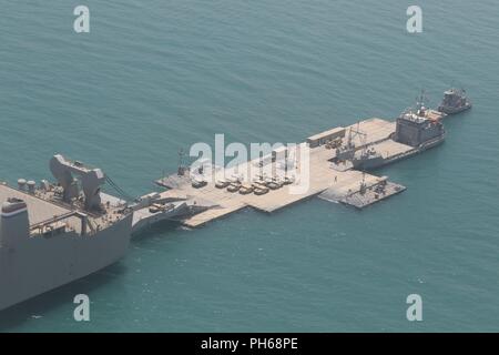 SHUAIBA PORT, Kuwait - Während der nautischen Horizont 2018, mehrere verehrte Besucher aus dem 1 Theater Sustainment Command, Kuwait militärischen und anderen Koalitionstruppen kam aus dem 24. Juni, in die von der US-Armee Schiffe in der Logistik teilnehmenden-über-dem Ufer Mission zu erhalten. Die DVs erhielt die Barge derrick Kran zu bereisen und flog in einem UH-60 über die Cape Ray mit dem Roll-on/Roll-off-Anlage Entlastung verbunden ist. Nautische Horizont 2018 ist eine 2-stufige U.S. Army Central Stockfoto