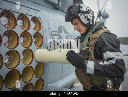 Norwegische See (27. Juni 2018) Naval Air Crewman (Hubschrauber) 2. Klasse William Levin sonobuoys prüft vor der Durchführung von Flugbetrieb in einem MH-60R Seahawk auf die "stolze Krieger" der Hubschrauber Maritime Strike Squadron (HSM) 72 zugeordnet. Farragut ist derzeit als Teil der Harry S. Truman Carrier Strike Group bereitgestellt. Mit USS Harry S. Truman (CVN 75) als Flaggschiff, bereitgestellt Streik Gruppe Einheiten gehören Personal, Schiffe und Flugzeuge von Carrier Strike Group Acht (CSG 8), Zerstörer Geschwaders zwei Acht (DESRON 28) und Carrier Air Wing (CVW-1); sowie die Sachsen-Klasse deutsche Fregatte FGS Stockfoto