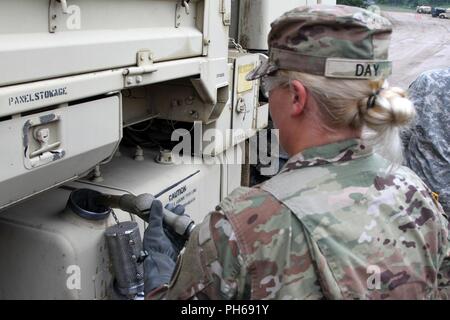 Pvt. Kayla Tag, die Petroleumversorgung Spezialist mit Unternehmen ein, die Unterstützung der Feuerwehr 237th Battalion, liefert Kraftstoff zu einem Light Medium Tactical Vehicle (LMTV) während der jährlichen Trainings 24. Juni im Camp Äsche gemeinsame Manöver Training Center in Grayling, Mich (Ohio Army National Guard Stockfoto