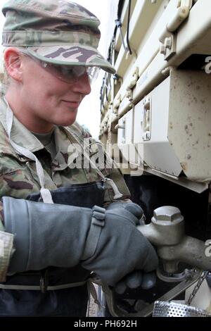 Pvt. Kayla Tag, die Petroleumversorgung Spezialist mit Unternehmen ein, die Unterstützung der Feuerwehr 237th Battalion, liefert Kraftstoff zu einem Light Medium Tactical Vehicle (LMTV) während der jährlichen Trainings 24. Juni im Camp Äsche gemeinsame Manöver Training Center in Grayling, Mich (Ohio Army National Guard Stockfoto