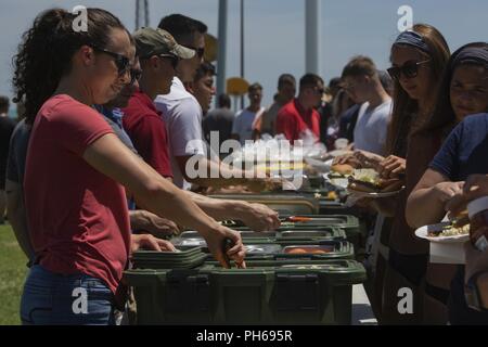 Us-Marines mit Sitz Battalion, 2nd Marine Division Essen servieren zu den Marinen und Seeleuten während einer Einheit Beach Bash in Onslow Strand in Camp Lejeune, N.C., 28. Juni 2018. Die zentrale Bataillon Beach Bash ist eine jährliche Veranstaltung für Marinesoldaten und Matrosen Einheit Kameradschaft zu bauen und feiern Tag der Unabhängigkeit. Stockfoto