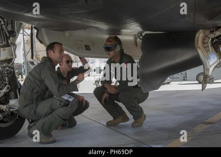 Us-Flieger Kapitän Timothy 'Check' Sechs und Kapitän Timothy 'Check' Sechs, Piloten, zu Hill Air Force Base, Arizona, bevorstehenden Übungen mit US Marine Corps Personalsgt diskutieren. Richard R. Wharton, eine Aviation ordnance Techniker mit Marine Fighter Attack Squadron (Vmfa) 122, Marine Corps Air Station (WAB) Yuma, auf MCAS Yuma, Ariz., 26. Juni 2018. Die Ausübung getestet, zum ersten Mal, die Interoperabilität der Systeme laden die Waffe zwischen den Dienstleistungen F-35. Die US Air Force arbeitet mit der F-35 Lightning II EIN, während das US Marine Corps arbeitet mit der F-35 B Blitz II. Stockfoto