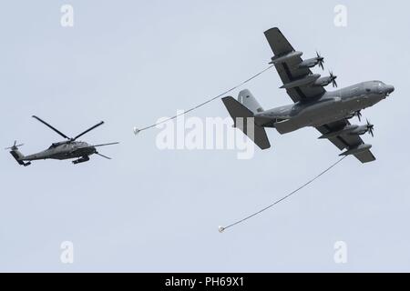 Eine Alaska Air National Guard HC-130J releases ein HH-60G Pave Hawk während der gemeinsamen Kraft Demonstration auf dem Arctic Thunder Open House besondere Bedürfnisse und Verteidigungsministerium Family Tag bei Joint Base Elmendorf-Richardson, Alaska, 29. Juni 2018. Während der Biennale open house, JBER öffnet seine Pforten für die Öffentlichkeit und Hosts, mehrere Akteure einschließlich der US Air Force Thunderbirds, JBER Joint Forces Demonstration und die US Air Force F-22 Raptor Demonstration Team. Stockfoto