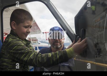 Henry, 10, schaltet die Steuerung Rad eines Civil Air Patrol Flugzeuge als CAP Maj. Derek Macpherson, Pilot, erklärt die CAP Mission während des Arctic Thunder Open House besondere Bedürfnisse und Verteidigungsministerium Family Tag bei Joint Base Elmendorf-Richardson, Alaska, 29. Juni 2018. Während der Biennale open house, JBER öffnet seine Pforten für die Öffentlichkeit und Hosts, mehrere Akteure einschließlich der US Air Force Thunderbirds, JBER Joint Forces Demonstration und die US Air Force F-22 Raptor Demonstration Team. Stockfoto