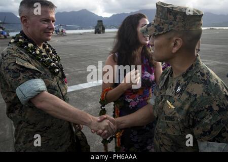 Us Marine Corps Oberst Christopher Patton, die Ausrückenden kommandierenden Offizier, Marine Aircraft Group (MAG) 24, 1. Marine Flugzeugflügel, schüttelt Hände mit Oberst Raul Lianez, kommandierender Offizier, Marine Corps Base Hawaii, nach der MAG 24 Ändern des Befehls Zeremonie, Marine Corps Base Hawaii, 29. Juni 2018. Oberst Patton Befehl aufgegeben zu oberst StephenLightfoot. Stockfoto