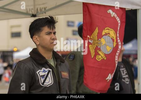 Us Marine Corps Kapitän Zachary Ybarra, ein AV-8B Harrier pilot zugeordnet Marine Attack Squadron (VMA) 214, Marine Corps Air Station Yuma, Ariz., steht an der Stelle der Aufmerksamkeit während der nationalen Hymne an die 2018 Arctic Thunder Air Show in Joint Base Elmendorf-Richardson, Alaska, 30. Juni 2018. VMA-214 Marines leitete einen vorbeiflug und schweben Demonstration mit Ihren AV-8B Harrier während der Air Show. Stockfoto