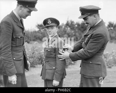 Drei amerikanische Piloten der Nr. 71 (Eagle) Squadron der Royal Air Force zeigen ihre neuen Geschwader Abzeichen an der Kirche Fenton, Yorkshire, Okt. 1940. Drei "eagle Staffeln wurden zwischen 1940 und 41 von US-Bürger in die RAF gebildet. Ursprünglich hatten die britischen kommandierenden Offiziere, eine Kombination von US-amerikanischen und britischen Piloten und britischen Bodenpersonal. Stockfoto