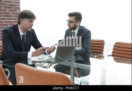 Zwei Geschäftsleute über Aufgaben im Büro sitzen. Stockfoto