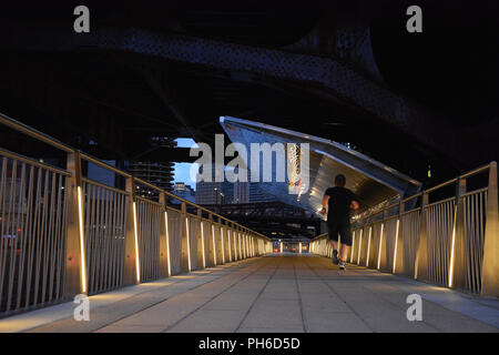 Am frühen Morgen Läufer Joggen entlang der Chicago Riverwalk unter der LaSalle St. Brücke. Stockfoto