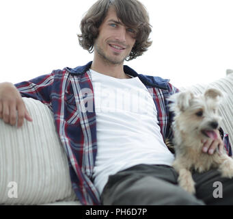 Stilvolle Kerl sitzen auf der Couch mit seinem Hund. Stockfoto