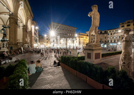 Florenz, Italien - 2018, Juli 09: Touristen geniessen die Sommernacht, in der Piazza della Signoria. Michelangelos "David im Vordergrund. Stockfoto