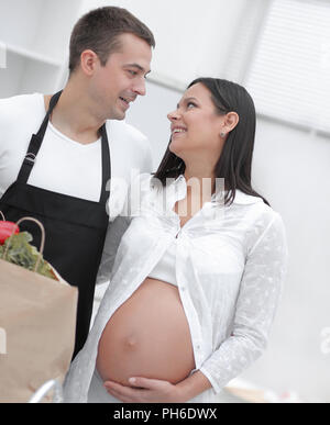 Mann und seine schwangere Frau sind Kämmen durch die Pack, stehen in der Küche Stockfoto