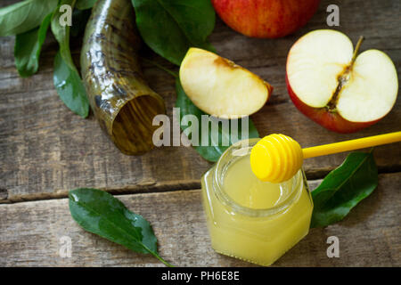 Hintergrund Rosch Haschana (das Jüdische Neue Jahr). Traditionelle Urlaub Symbole - schofar, Honig und Apfel auf eine Küche Holztisch. Stockfoto