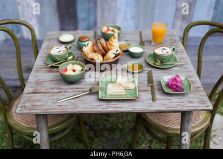 Das Frühstück draußen im Garten auf vintage Holztisch Stockfoto