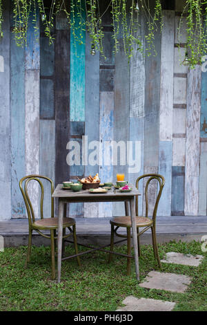 Das Frühstück draußen im Garten auf vintage Holztisch Stockfoto