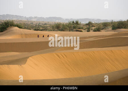 Nomaden, die in der Wüste Thar bei Jaisalmer, Rajasthan, Indien, spazieren gehen Stockfoto