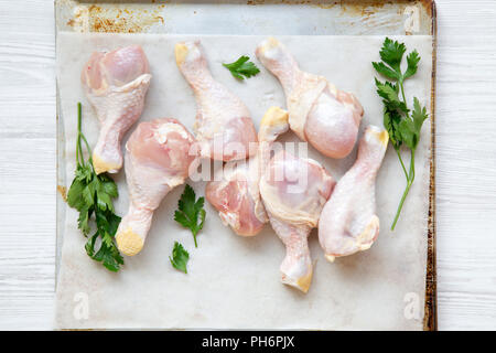 Ungekocht raw Hähnchenschenkel auf ein Backblech Papier in Fach, Ansicht von oben. Flach, Overhead, von oben. Stockfoto