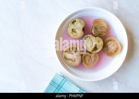 Cannned Grün Tomatenscheiben mit essiggurke Saft in Platte (die Hälfte erhalten und Gebeizt). Ökologische Lebensmittel. Stockfoto