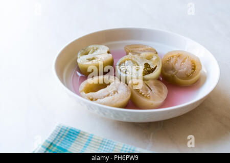 Cannned Grün Tomatenscheiben mit essiggurke Saft in Platte (die Hälfte erhalten und Gebeizt). Ökologische Lebensmittel. Stockfoto