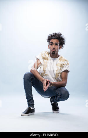 Hip Hop Tänzer hocken und in die Ferne schauen, Stockfoto