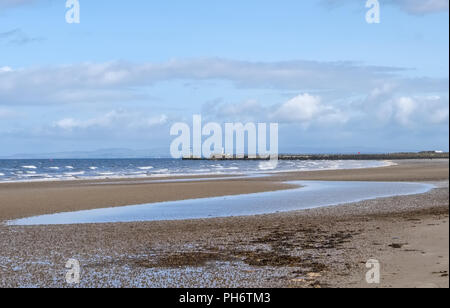 Auf der Suche nach Ayr Strand in Richtung des Lichts Haus und Meer Wand an einem hellen Tag im August. Stockfoto