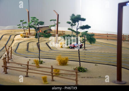 Kleines Spielzeug Haus, rotes Auto, Bäume und Laterne in Spielzeug, Anschluss Stockfoto