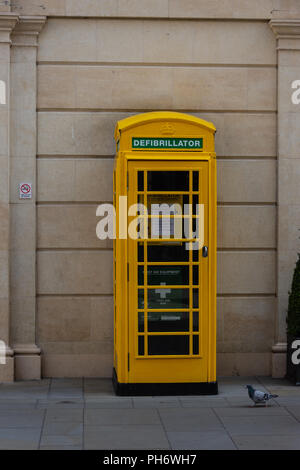 Traditionelle Telefon box Gelb gestrichen und verwendet für einen Defibrillator gespeichert und von der Öffentlichkeit im Notfall zugegriffen werden. Stockfoto