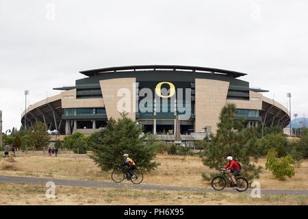 Menschen zu Fuß und Fahrrad vor Autzen Stadium an der Universität von Oregon in Eugene, Oregon, USA. Stockfoto