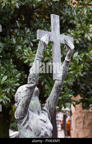 Mailand, Italien. 2018/2/8. Die Statue einer Frau, die mit einem Kreuz auf einem grabstein an der Cimitero Monumentale ('Monumental Friedhof') in Mailand, Italien. Stockfoto
