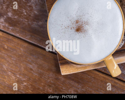 Close-up weißer Schaum Abdeckung oben auf eine Tasse heißen Kaffee auf Holz- Fach auf hölzernen Tisch Hintergrund Ansicht von oben mit der Kopie. Stockfoto