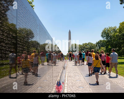 Vietnam Veterans Memorial mit Touristen und Washington Monument im Hintergrund Stockfoto