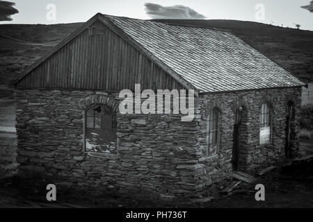 Ein altes Haus mit kaputten Fenstern in der Dämmerung in Storwartz, außerhalb von Røros (ROROS), Norwegen. Stockfoto