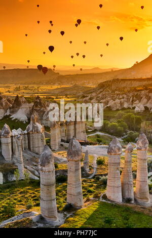 Liebe Vally und Ballons auf dem Sonnenaufgang Himmel, Kappadokien, Türkei Stockfoto