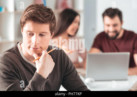 Schöne nachdenklicher Mann hält sein Kinn Stockfoto