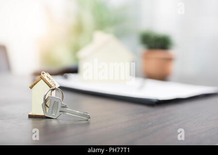 Haus Schlüssel auf Tabelle mit Vertragsformular, Verkauf und Kauf von Haus oder Eigentumswohnung Konzept Stockfoto
