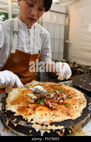 London, Großbritannien. 31. August 2018. Ein Koch bereitet ein Pfannkuchen Teller am Eröffnungstag der drei Tag Chinese Food Festival in Potters Felder Park neben dem Rathaus. Sowie essen und trinken aus den verschiedenen Teilen Chinas frisch zubereitet für Besucher, um zu versuchen, es gibt Kochvorführungen und Präsentationen von der britischen Han Kultur Verband. Credit: Stephen Chung/Alamy leben Nachrichten Stockfoto