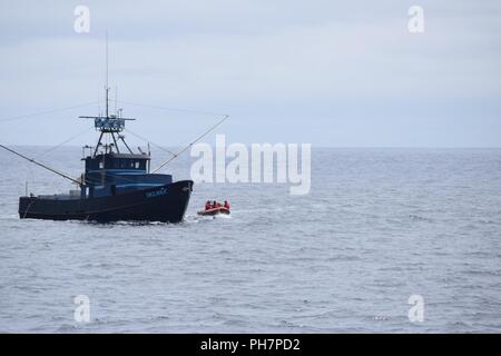 Ein Boarding Team an Bord eines kleinen Bootes von der Coast Guard Cutter Orcas, 110-Fuß-Patrouillenboot in Coos Bay, Erz homeported, Ansätze eines Fischereifahrzeugs aus die Küste von Oregon, 30. Juni 2018. Sicherheit boardings und Patrouillen werden regelmäßig durchgeführt, um die Sicherheit des Pazifischen Nordwestens Fischereiflotte zu gewährleisten. Stockfoto