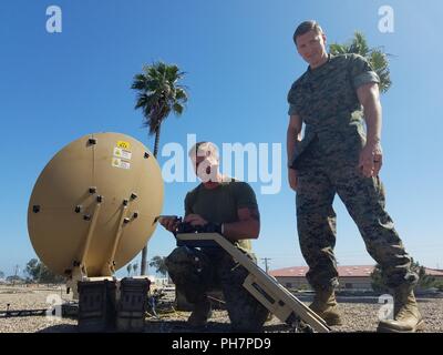 MARINE CORPS BASE CAMP Pendleton, Calif (26. Juni 2018) US Marine Corps Sgt. Alex Cooper, Links, Satellitenbetreiber, 15 Marine Expeditionary Unit (MEU), stellt die Hawkeye-III-Satelliten mit Kapitän Austin Yagle, Communications Officer, 15. MEU, während der Rand des Pazifik (Rimpac) Übung im Marine Corps Base Camp Pendleton, Kalifornien, 26. Juni 2018. RIMPAC bietet hochwertige Ausbildung für Task-organisierte, hoch-fähigen Marine Air-Ground Task Force und erhöht die kritische Reaktion auf Krisen Fähigkeit der US-Marines im Pazifik. 25 Nationen, 46 Schiffe, 5 U-Boote, ca. 200 Stockfoto