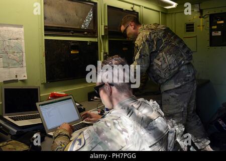 Us-Armee Cpl. MacKenzie Salas, ein unbemanntes Flugzeug system mission Koordinator, und Warrant Officer Brandon Dupius, UAS Flug Programm Manager, sowohl für die Reiter platoon Delta Firma zugewiesen, 91st Brigade Ingenieur Bataillon, 1st Armored Brigade Combat Team, 1.Kavallerie Division, bereitet die Antrittsrede eine RQ-7B Schatten des Unmanned Aircraft Systems Flug aus der Reiter Flug Landeplatz in Zagan, Polen, 29. Juni 2018. Der platoon Die erste taktische UAS Flug in Polen. Sie sind derzeit zur Unterstützung der Atlantischen lösen in Europa eingesetzt. Stockfoto
