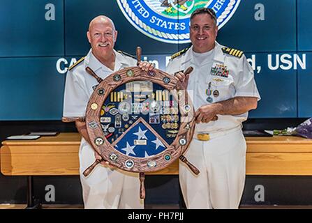 Defense Supply Center Columbus ehemaliger Kommandant und pensionierter Navy hinten Adm. John King präsentiert Marine Kapitän Justin D. Debord mit einem traditionellen Naval Schatten ein Andenken an seine Leistungen im Namen seiner Direktion. Stockfoto