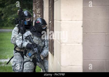 Flieger von der 23d Security Forces Squadron (SFS) geben Sie ein Gebäude während eine Kraft auf Kraft training Szenario, 29. Juni 2018, bei Moody Air Force Base, Ga in dieser Schulung wurde gehalten, um sicherzustellen, dass SFS Flieger in verschiedenen Taktiken und Verfahren, wie z. B.: Gebäude klar heraus, team Bewegungen, geiselbefreiung und ordnungsgemäß anwenden Abdeckung Feuer mächtig sind. Das Szenario erforderlichen Flieger durch mehrere Gebäude zu manövrieren eine simulierte Opfer von gegensätzlichen Kräfte zu retten. Stockfoto