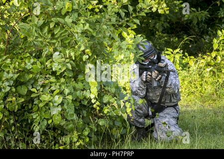 Einen Flieger aus der 23d Security Forces Squadron (SFS) bereitet seine M4 Carbine während eine Kraft auf Kraft training Szenario, 29. Juni 2018, bei Moody Air Force Base, Ga. Dieses Training zu Feuer gehalten wurde, um sicherzustellen, dass SFS Flieger in verschiedenen Taktiken und Verfahren, wie z. B.: Gebäude klar heraus, team Bewegungen, geiselbefreiung und ordnungsgemäß anwenden Abdeckung Feuer mächtig sind. Das Szenario erforderlichen Flieger durch mehrere Gebäude zu manövrieren eine simulierte Opfer von gegensätzlichen Kräfte zu retten. Stockfoto