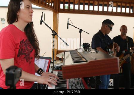 PRIŠTINA, Kosovo - 1 Lt Allison Spurgin, Material Management Center Chief von Orange County, CA., spielen die e-piano, Maj. James Mendoza, Brigade Human Resources Officer von Lincoln, Ca. Spielen der akustischen Gitarre und SPC. Michael Pardubsky, ein Fahrer und Bassist aus San Diego, Ca., alle mit der 79th Infantry Brigade Combat Team, Kalifornien Nationalgarde, in dem multinationale Schlacht Group-East vertreten Camp Bondsteel in eine Leistung für die Botschaft der Vereinigten Staaten im Kosovo auf ihrer vierten Juli Feier am 30. Juni. Die "bondsteel Band', spielte klassische Hi Stockfoto