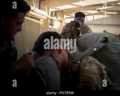 Spc. Stephan Englisch eine Bekämpfung Dokumentation / Produktion Spezialisten zu 55th Signal Company, Fort George G. Meade, Maryland zugewiesen wird in Position zu den Fotos von US-Fallschirmjäger Erfassung während ein Betrieb die Ausbildung an der Grünen Rampe in Fort Bragg, North Carolina, 19. Juni 2018. Der Zug gehören Aktionen im Flugzeug, Vor-sprung Schulung und Fallschirmlandung fallen. Stockfoto