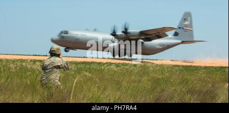 Staff Sgt. Samuel Lopez eine Bekämpfung Dokumentation / Produktion Spezialisten zu 55th Signal Company in Fort George G. Meade zugeordnet, Maryland in Position erhält Fotos einer Luftwaffe C-130 bei einem Betrieb Ausbildung in Fort Bragg, North Carolina, 19. Juni 2018 zu erfassen. Der Zug gehören Aktionen im Flugzeug, Vor-sprung Schulung und Fallschirmlandung fallen. Stockfoto