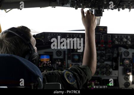 Ein US Air Force Pilot an der 72nd Flugzeugbetankung Geschwader zugewiesen stellt eine Kurzwahl auf einer KC-135 Stratotanker R über dem Atlantik, 19. Juni 2018. Die KC-135 ist eine Betankung von Flugzeugen, die In-flight Treibstoff für Flugzeuge wie F-16 CM Kampf gegen die Falken, die die Unterdrückung der gegnerische Luftabwehr Mission bietet. Stockfoto