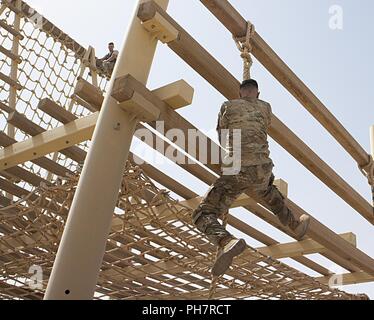 38Th Sustainment Brigade Sgt. Zachary Grün klettert das Seil zu Beginn der Airborne Hindernis Kurs während der US-Army Central besten Krieger Wettbewerb im Camp Beuhring, Kuwait, am 29. Juni. Grüne ging auf die besten Krieger, den Wettbewerb zu gewinnen. Stockfoto