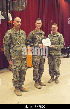 38Th Sustainment Brigade Soldat Sgt. Zachary Grün nimmt seine Auszeichnung als die US-Army Central besten Krieger für 2018 Ab 3. Armee Command Sgt. Maj. Joseph A. Cornelison und Generalmajor David C. Hill, 3. Armee stellvertretenden kommandierenden General, während einer Zeremonie im Camp Arifjan, Kuwait, Kapelle am 30. Juni. Stockfoto